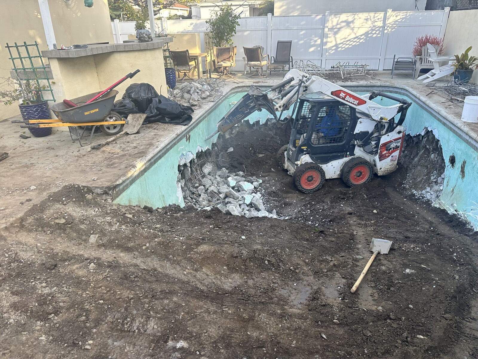 Empty in-ground concrete pool prepped for demolition